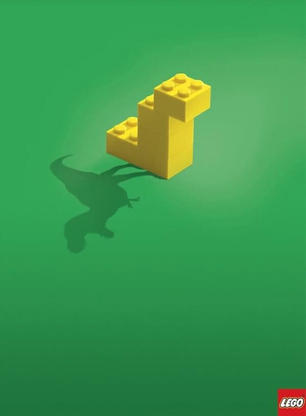 a lego ad that displays a t-rex in the shadow of a blocky lego shape