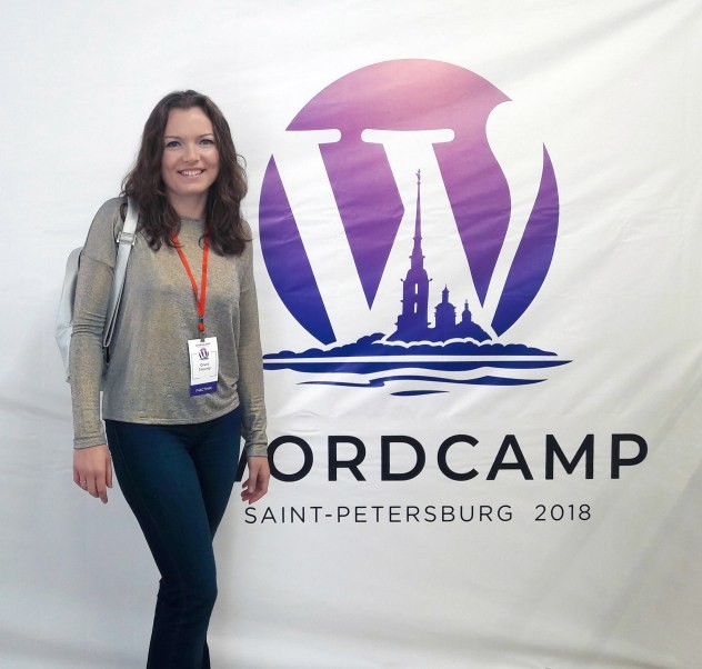 Olga next to a banner of WordCamp St Petersburg 2018