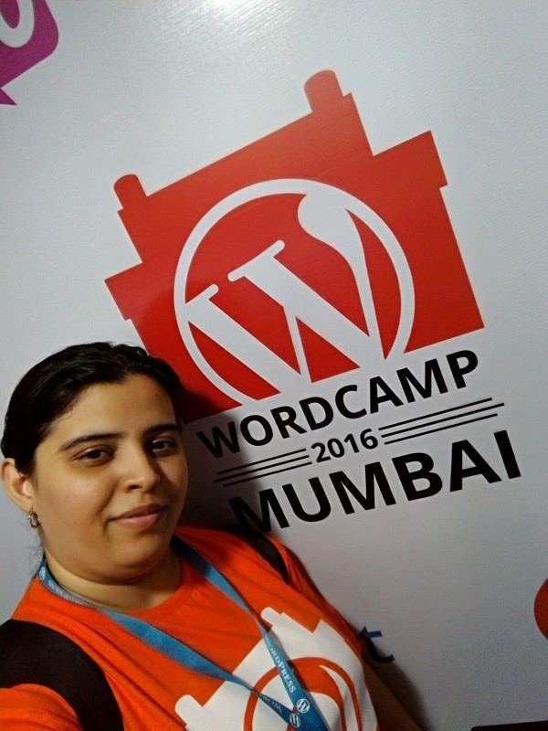 Meher pictured with the WordCamp Mumbai 2016 sign 