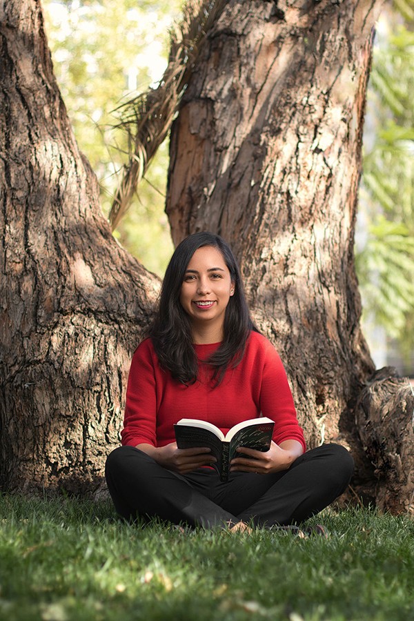 Carla reading a book under a tree