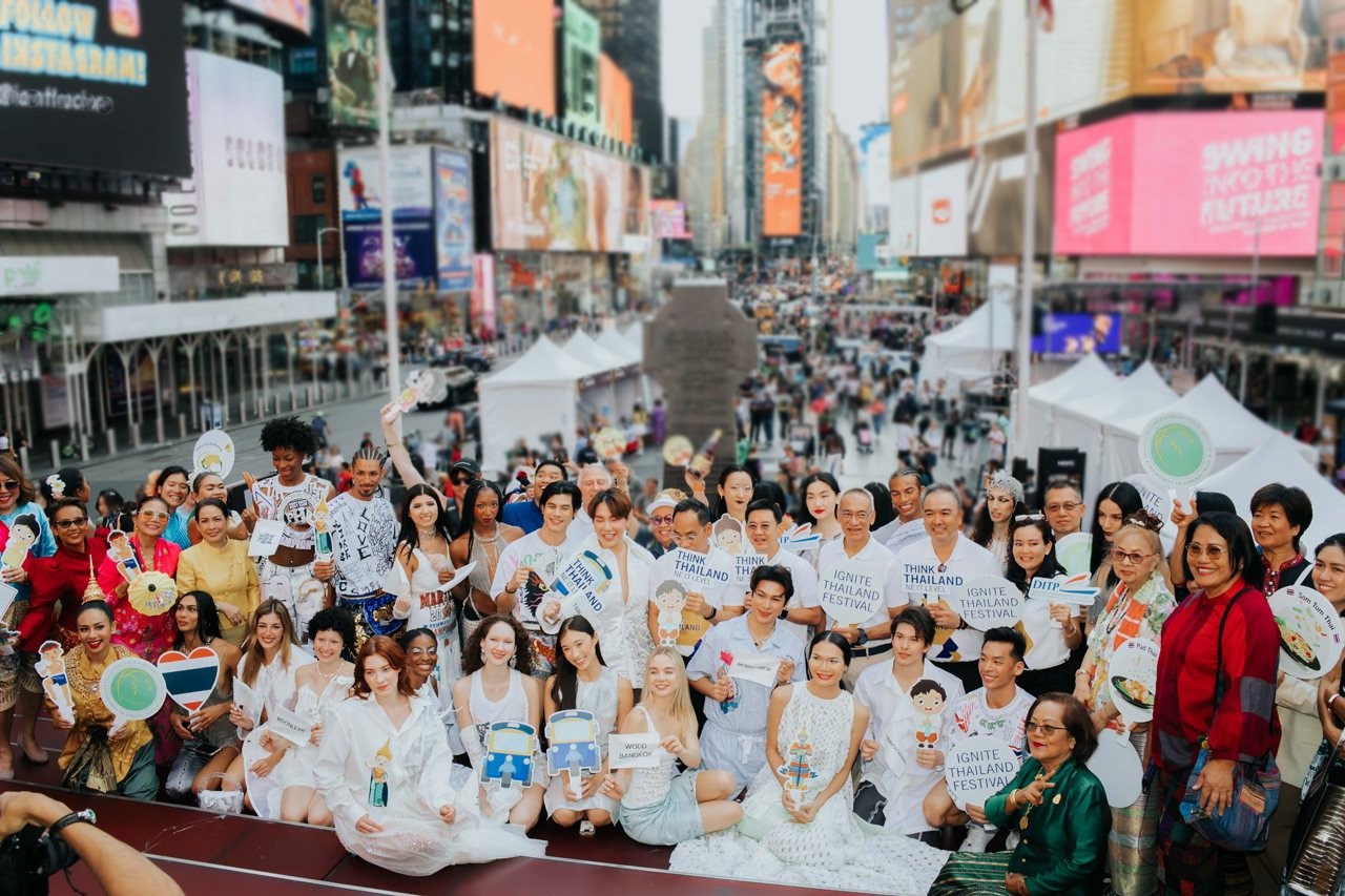 Large group of Thailand festival attendees near vendor booths in New York.