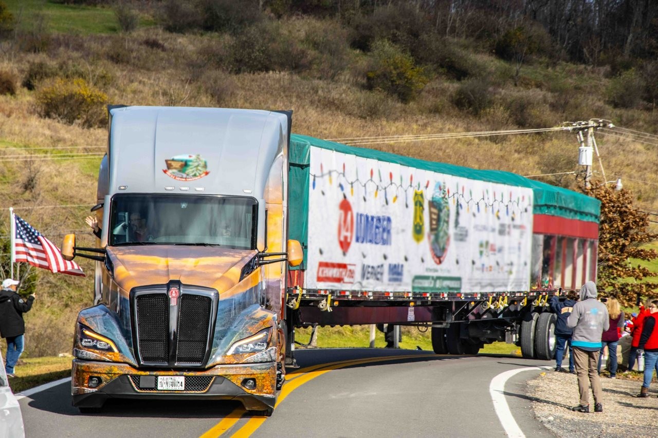 People along the road side wavying as the Christmas tree truck rolls by them on its journey to Washington D C.